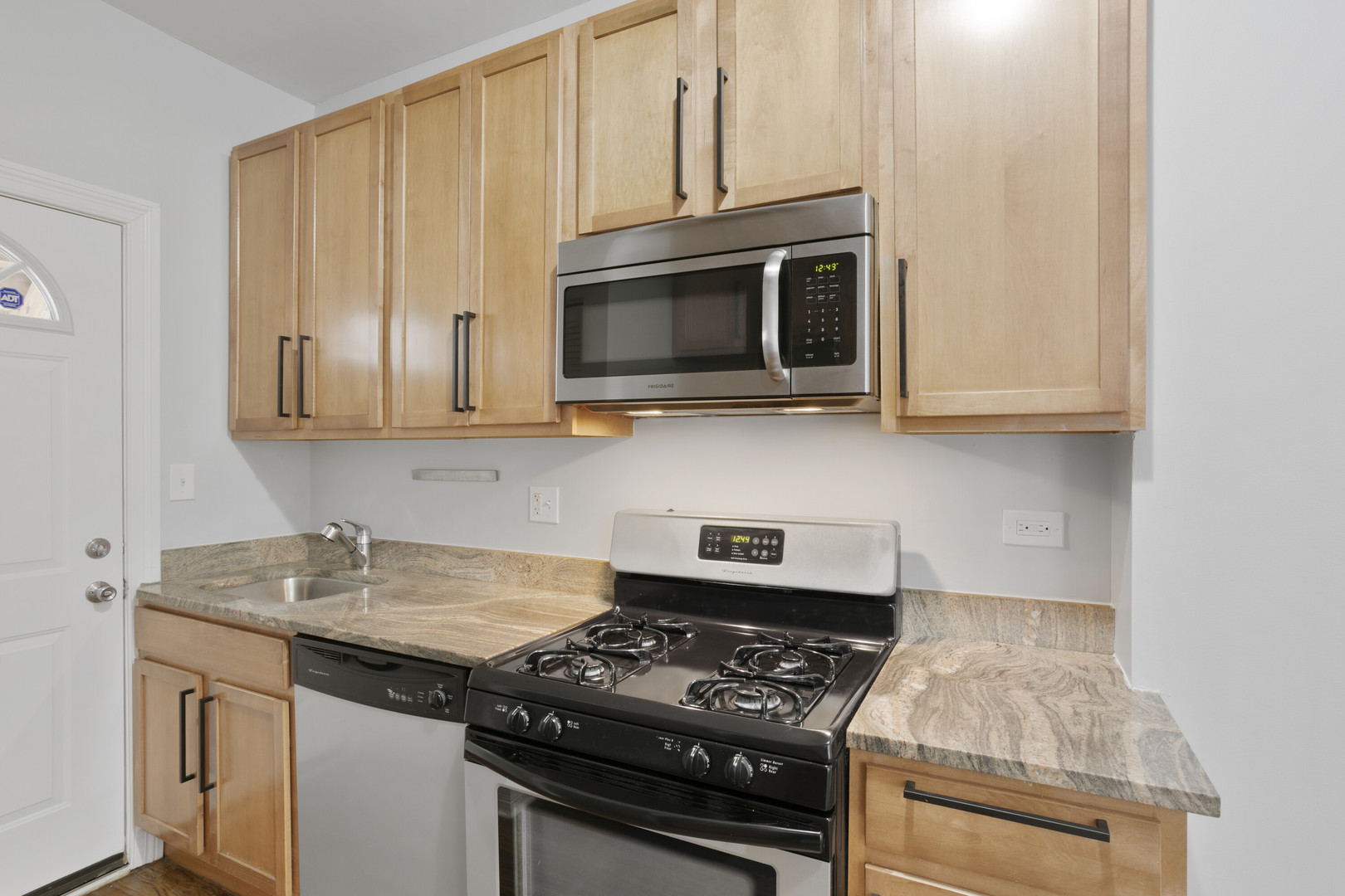 2005 West Jarvis Avenue, Unit 3 Chicago, IL 60645 - Photo 5 of 15 a kitchen with stainless steel appliances granite countertop white cabinets and black stove top oven with granite countertops
