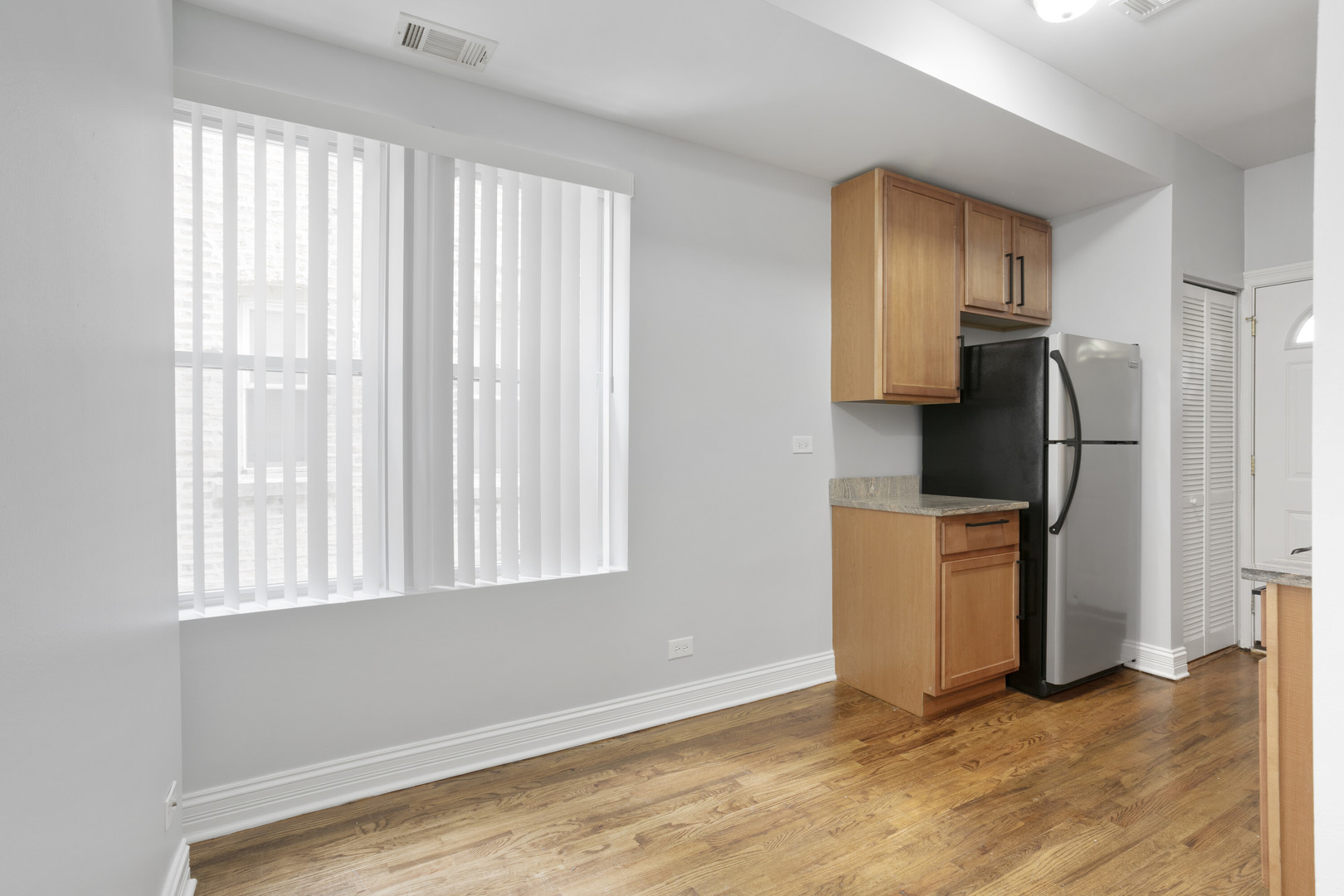 2005 West Jarvis Avenue, Unit 3 Chicago, IL 60645 - Photo 7 of 15 an empty room with a window and a refrigerator