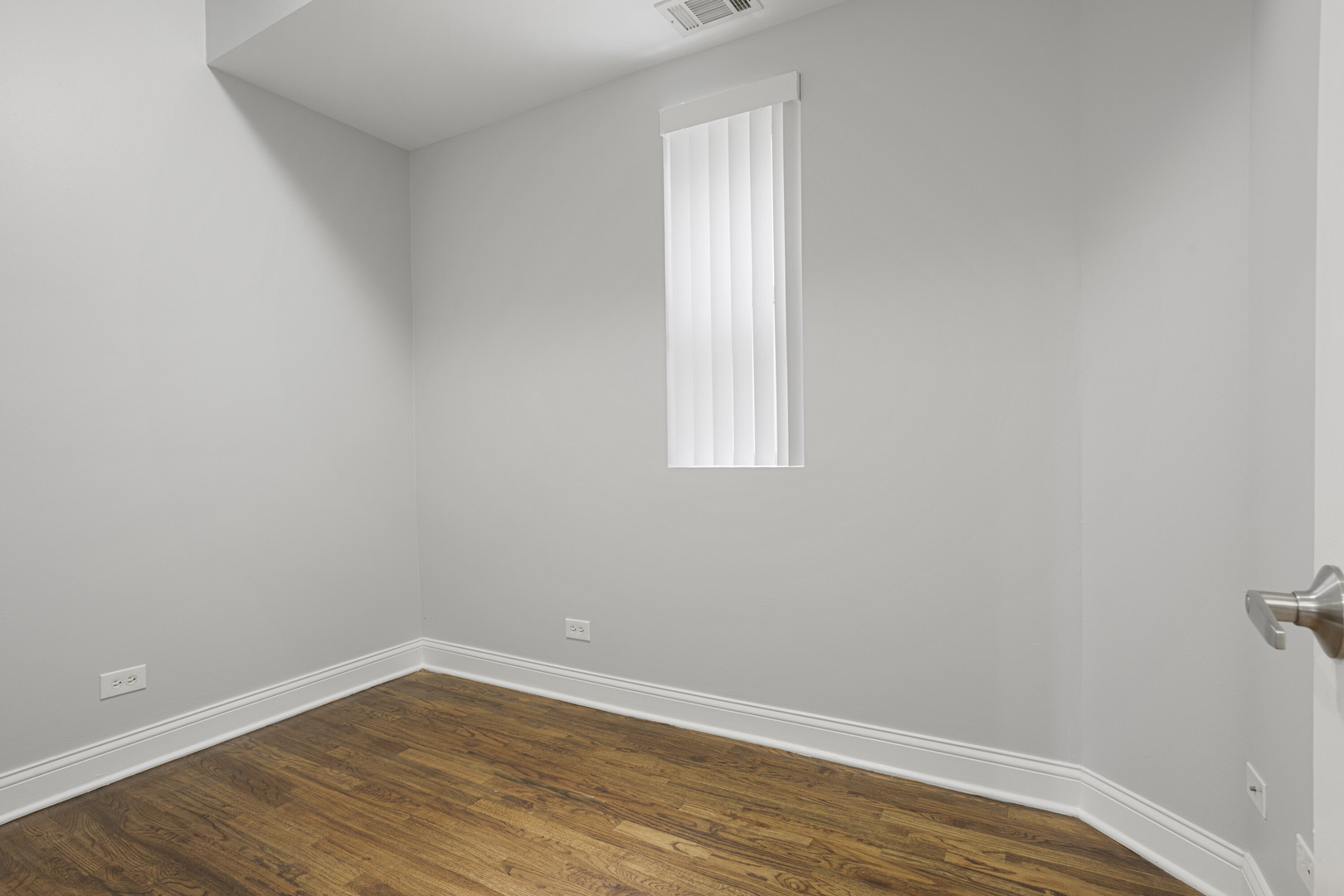 2005 West Jarvis Avenue, Unit 3 Chicago, IL 60645 - Photo 9 of 15 a view of an empty room with wooden floor and a window