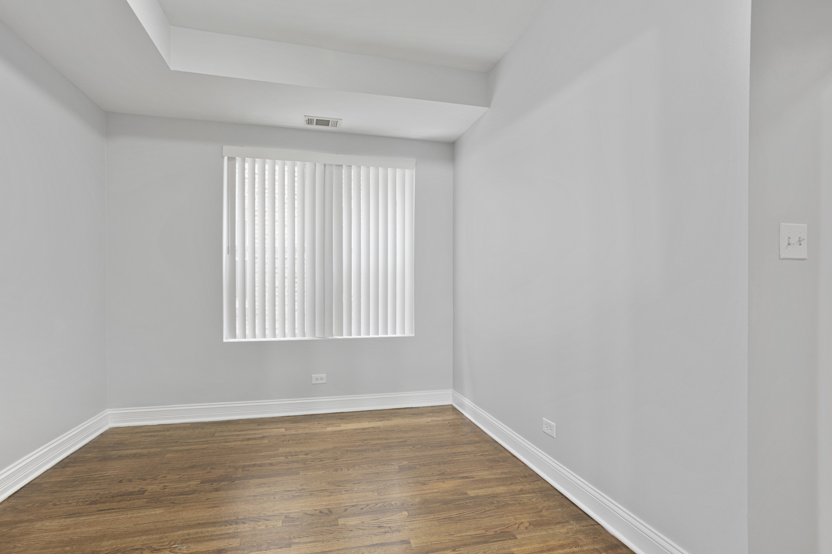 2005 West Jarvis Avenue, Unit 3 Chicago, IL 60645 - Photo 10 of 15 a view of an empty room with wooden floor and a window