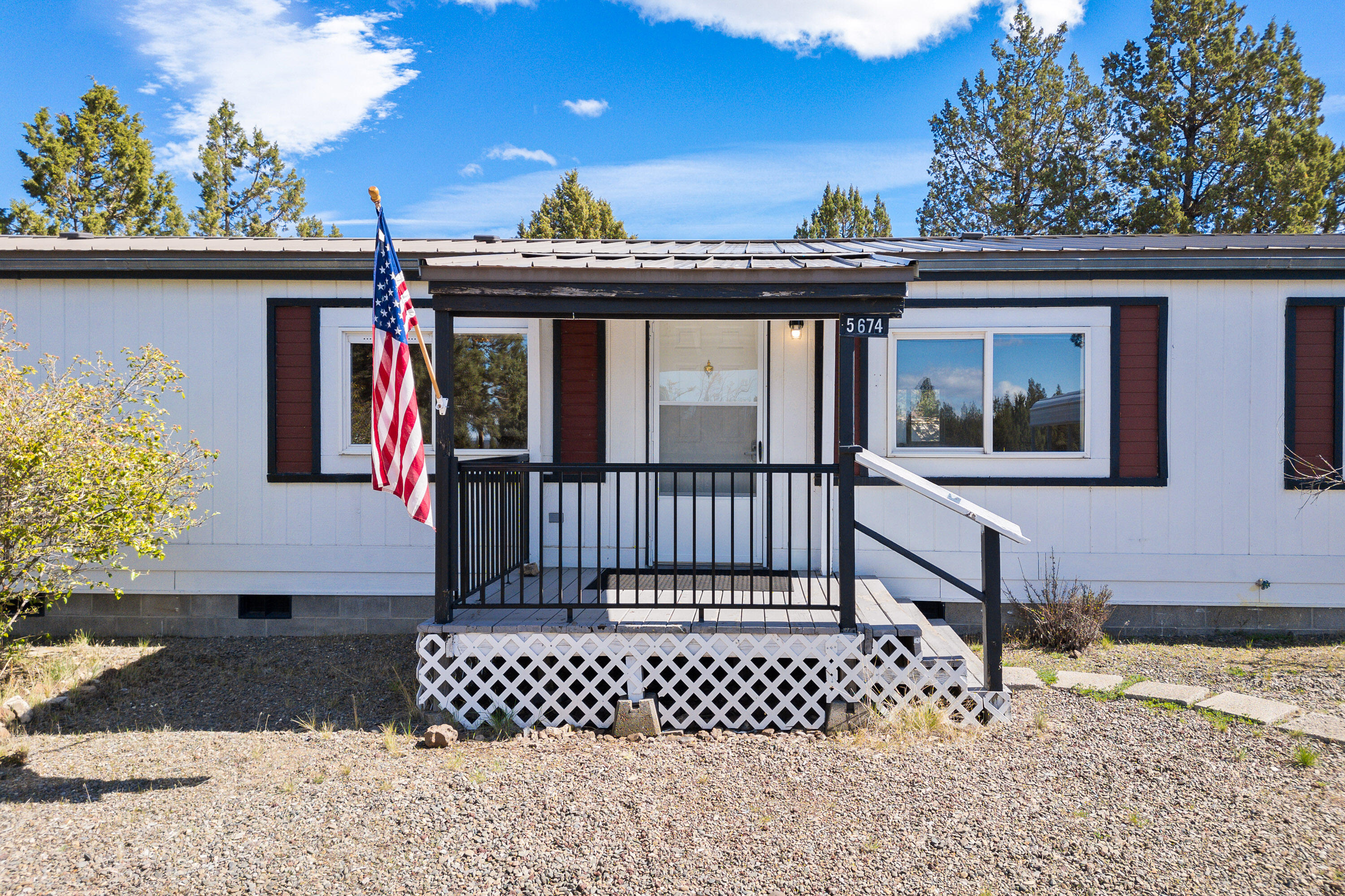 5674 Southeast Davis Loop Prineville, OR 97754 - Photo 1 of 48 a view of a brick house with large windows and a small yard
