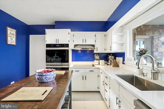 a kitchen with cabinets a sink and white appliances
