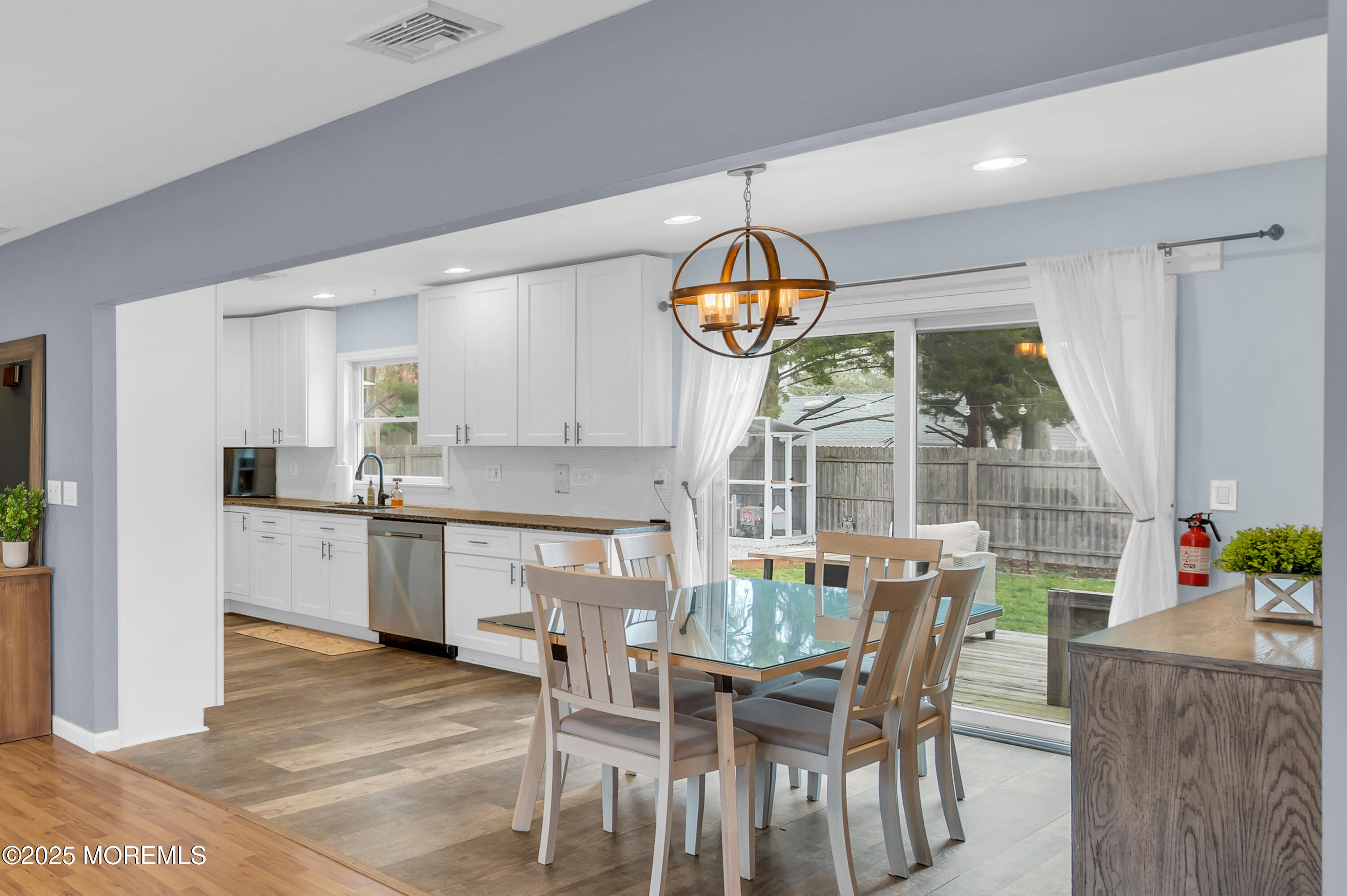 408 Cedar Drive Lanoka Harbor, NJ 08734 - Photo 7 of 39 a kitchen with stainless steel appliances granite countertop a dining table chairs and white cabinets