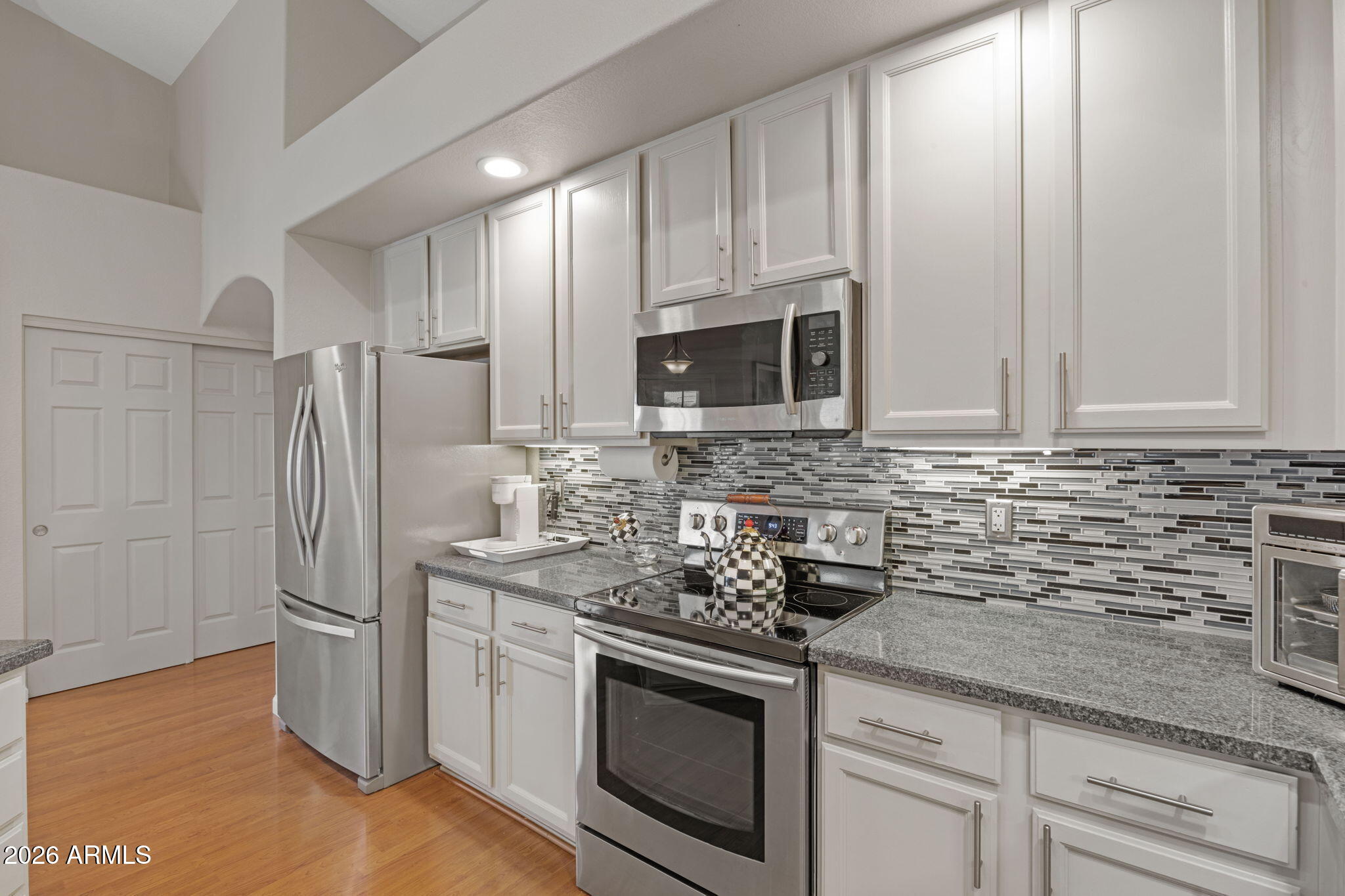 16008 South 38th Way Phoenix, AZ 85048 - Photo 14 of 47 a kitchen with stainless steel appliances granite countertop white cabinets a refrigerator and a sink