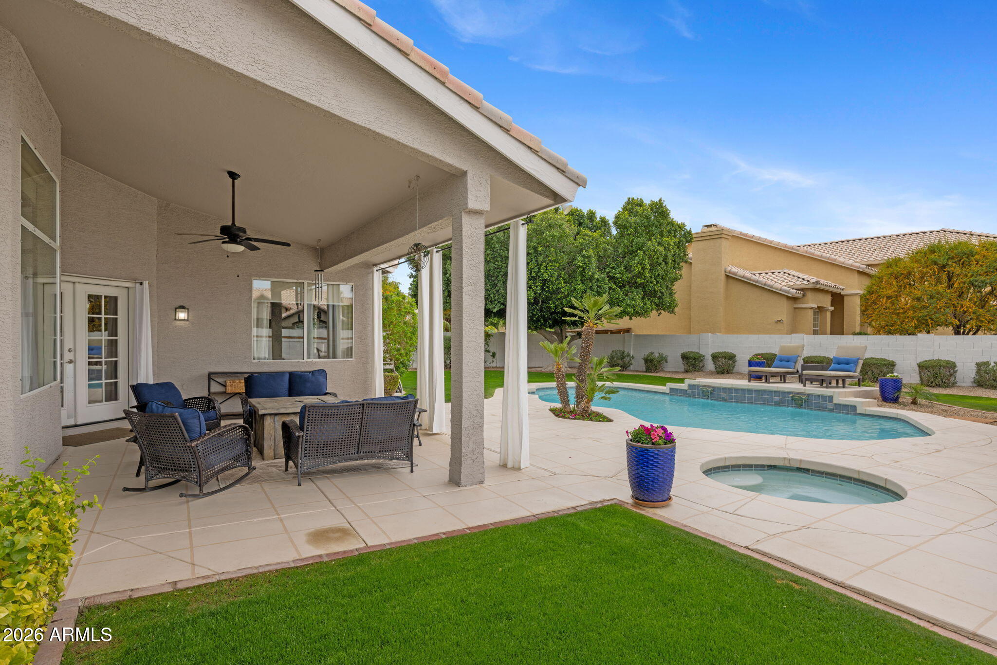 16008 South 38th Way Phoenix, AZ 85048 - Photo 37 of 47 a view of a patio with couches table and chairs under an umbrella