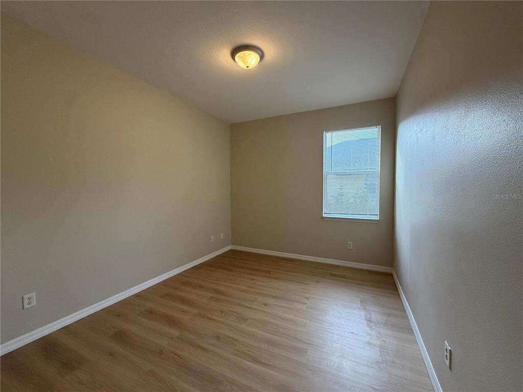 12418 24th Street East Parrish, FL 34219 - Photo 15 of 59 an empty room with wooden floor and windows