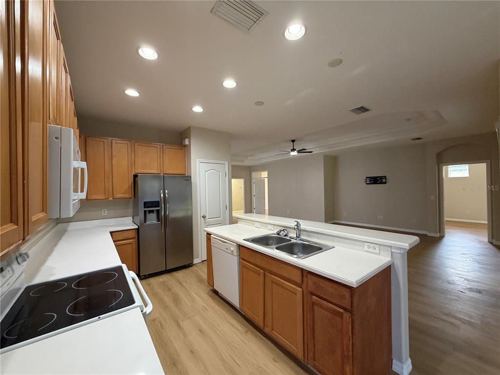 12418 24th Street East Parrish, FL 34219 - Photo 22 of 59 a kitchen with stainless steel appliances granite countertop a sink stove and refrigerator