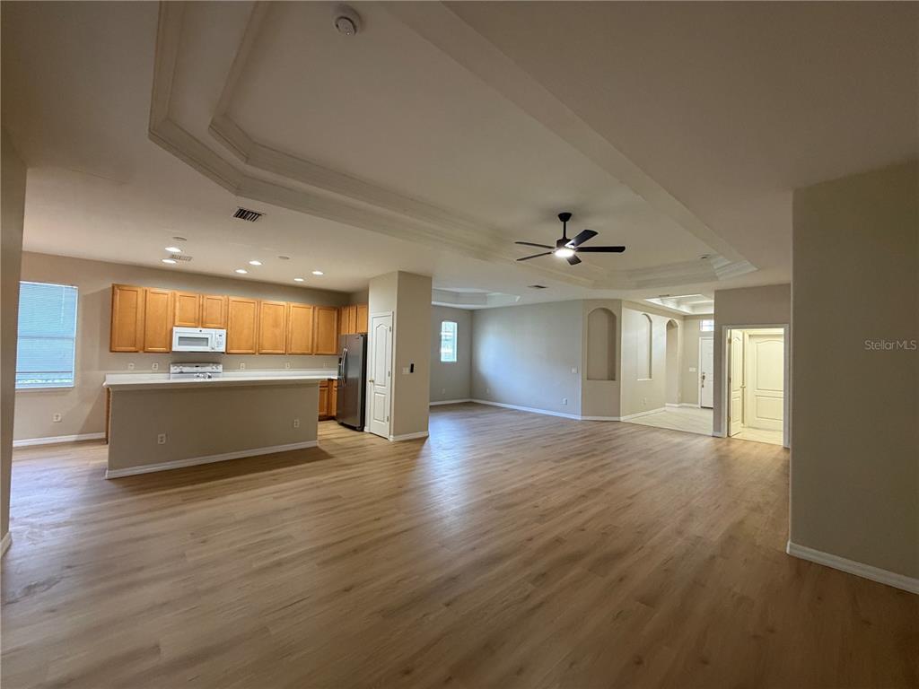 12418 24th Street East Parrish, FL 34219 - Photo 24 of 59 an empty room with wooden floor kitchen view and a window