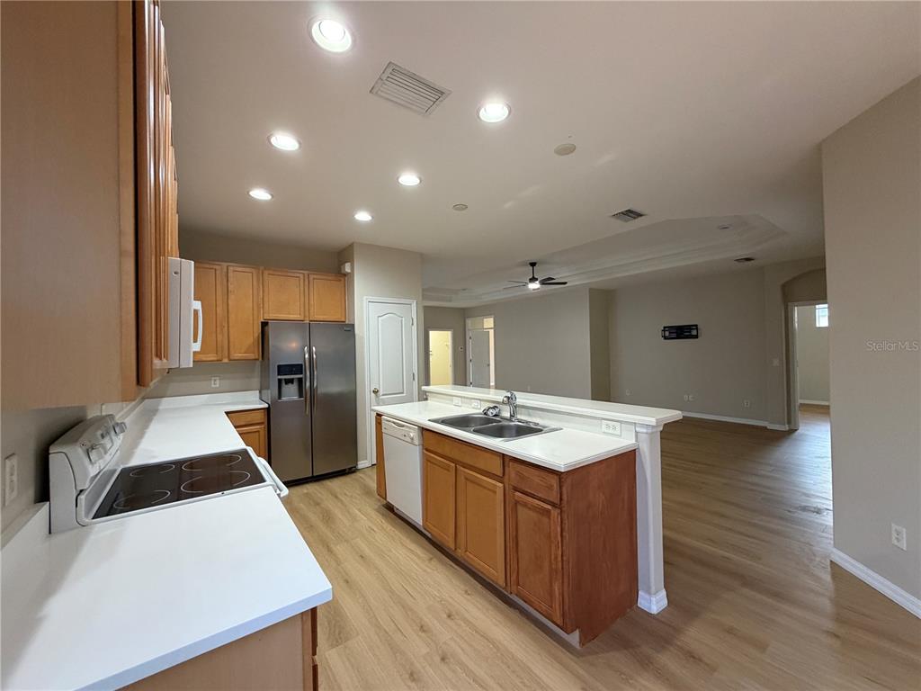 12418 24th Street East Parrish, FL 34219 - Photo 30 of 59 a kitchen with stainless steel appliances granite countertop a sink stove and refrigerator
