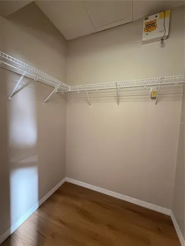 a view of an empty room with a window and a ceiling fan