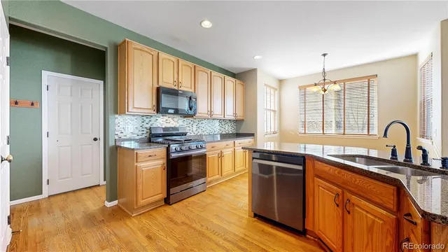 a kitchen with stainless steel appliances granite countertop a stove a sink dishwasher and a refrigerator
