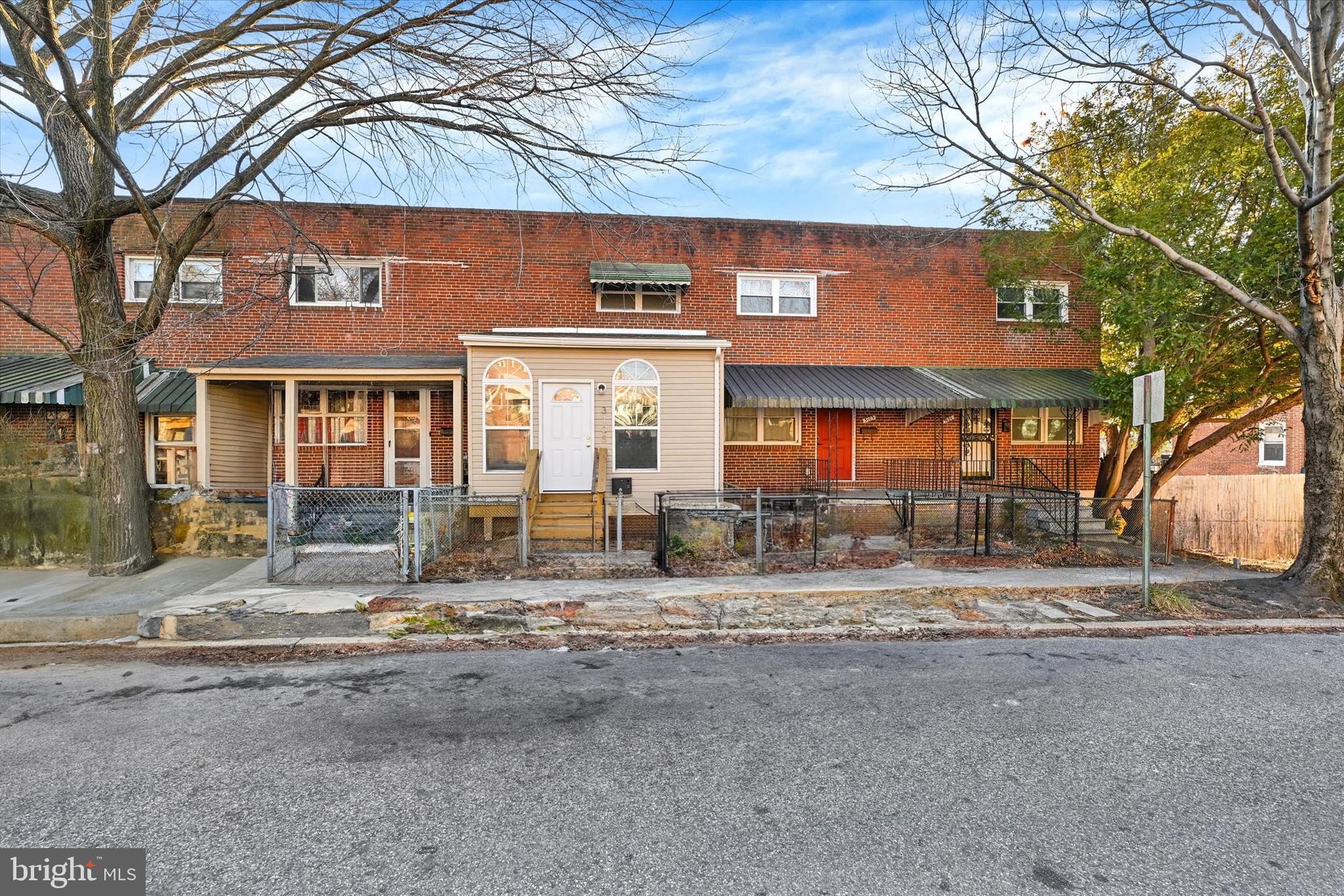 3105 Frisby Street Baltimore, MD 21218 - Photo 1 of 22 a view of a house with large windows and a tree