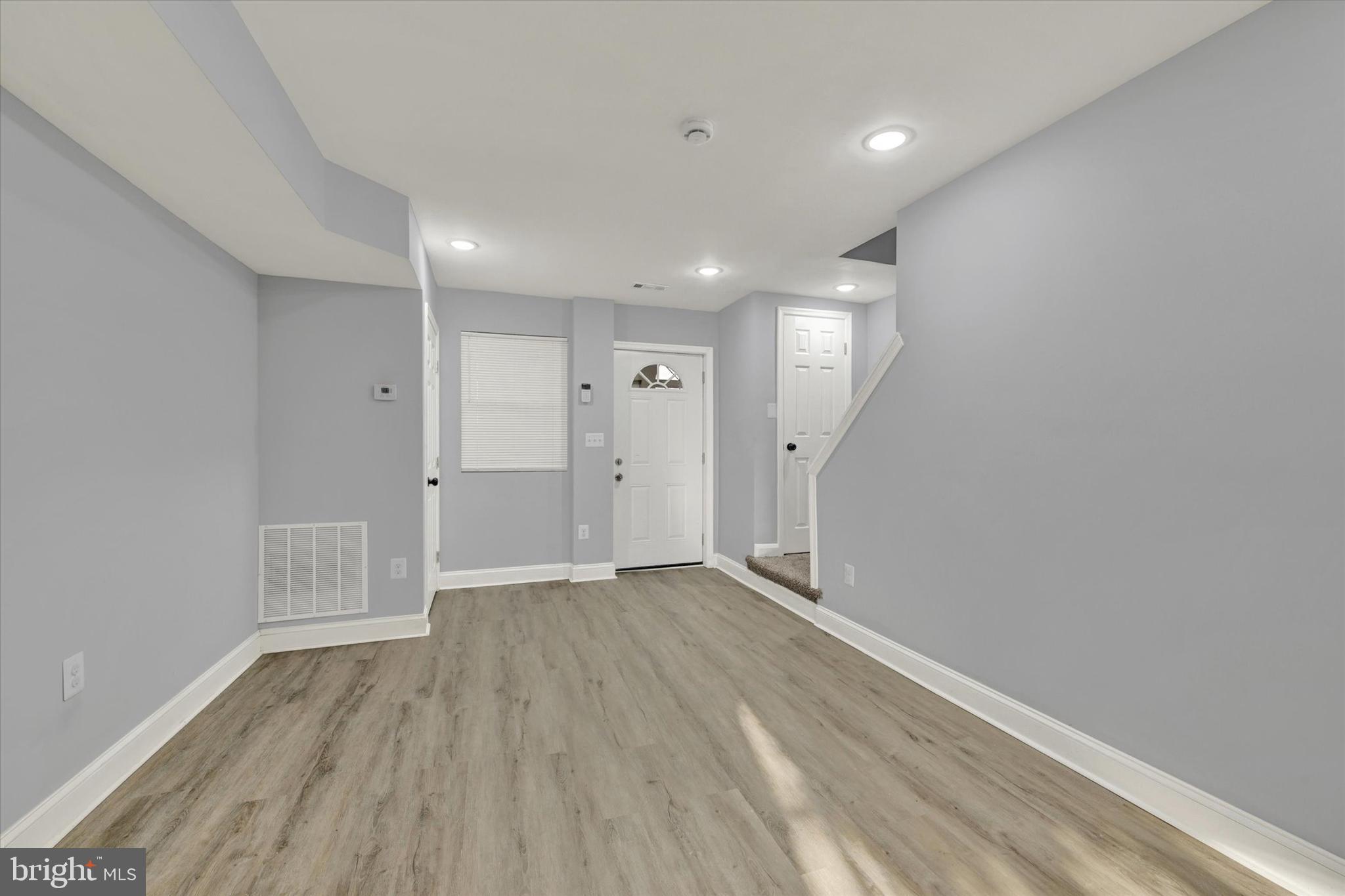3105 Frisby Street Baltimore, MD 21218 - Photo 5 of 22 wooden floor in an empty room with a window