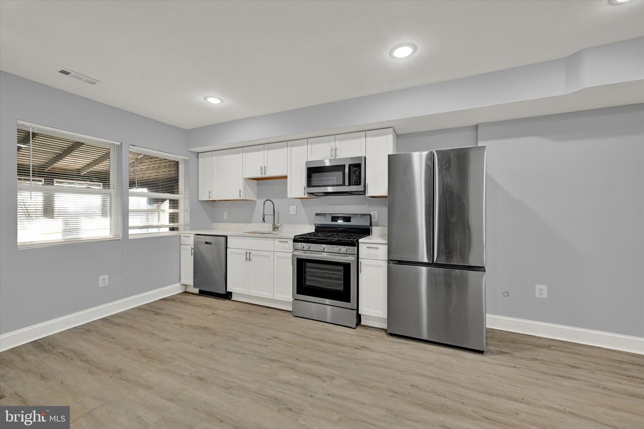 3105 Frisby Street Baltimore, MD 21218 - Photo 8 of 22 a kitchen with a refrigerator and a stove top oven