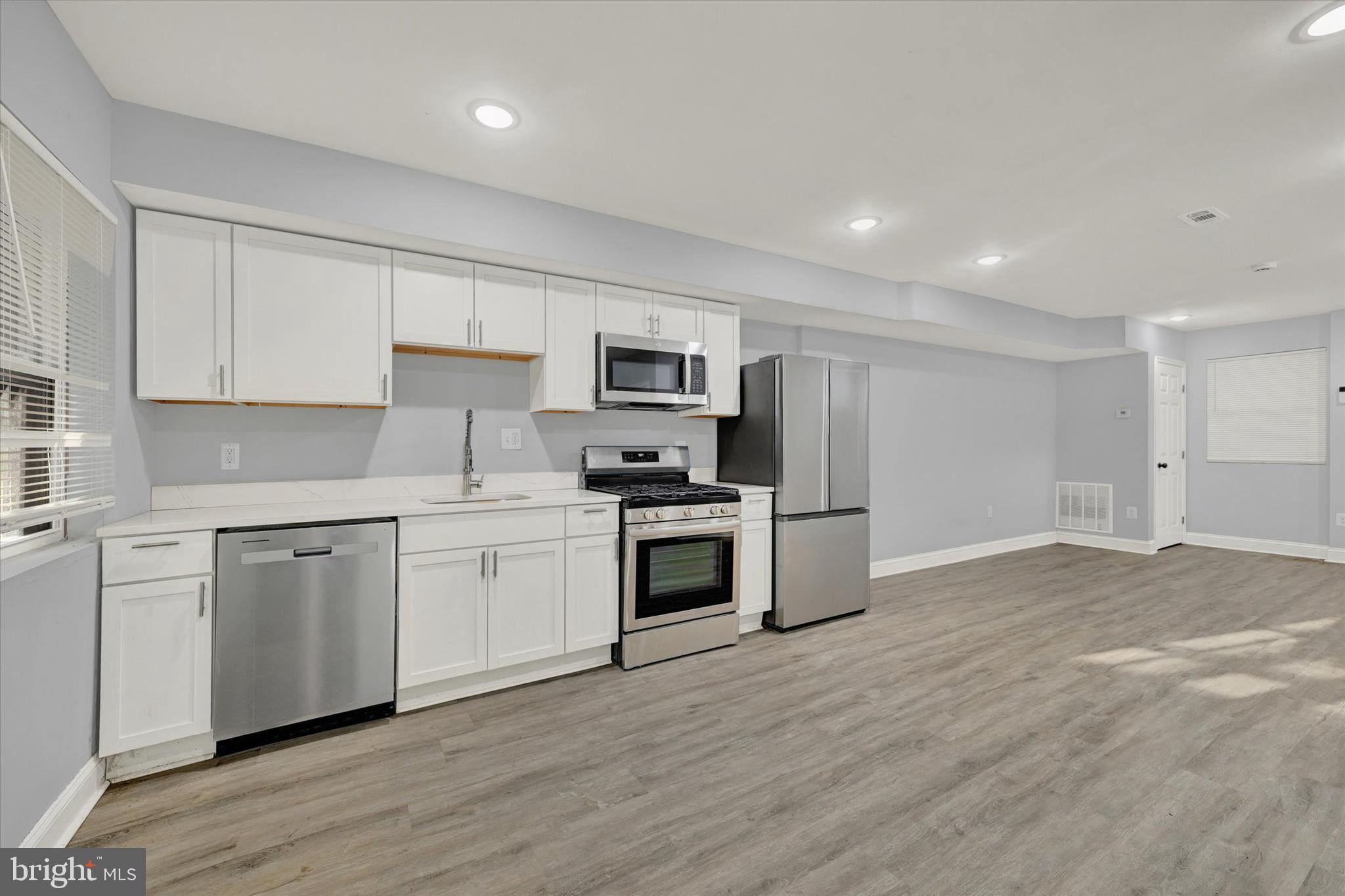 3105 Frisby Street Baltimore, MD 21218 - Photo 9 of 22 a kitchen with granite countertop a stove top oven and cabinets