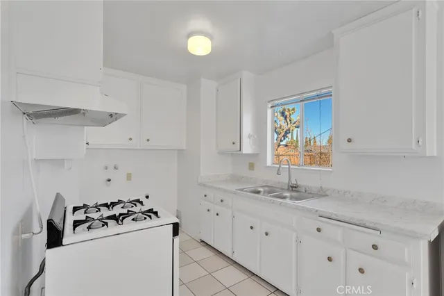 a kitchen with granite countertop white cabinets and white appliances