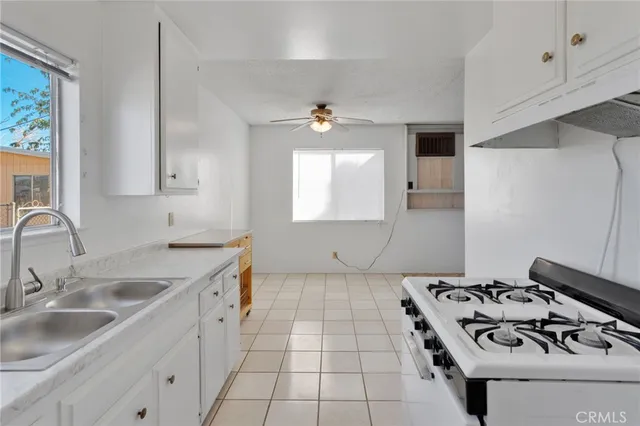 a kitchen with a stove sink and cabinets