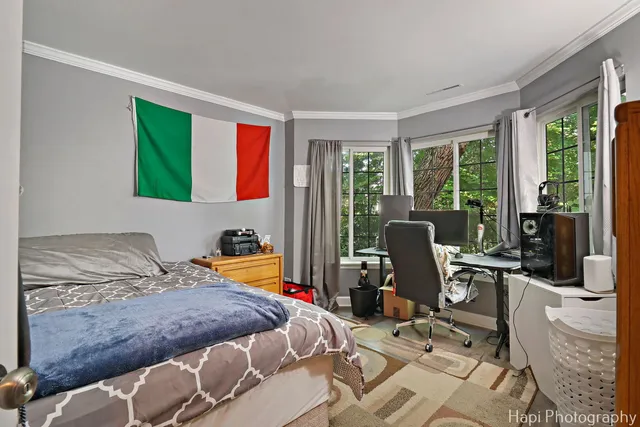 a bedroom with a bed and large windows