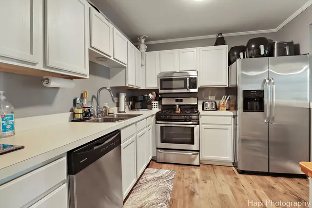 a kitchen with stainless steel appliances a refrigerator sink and microwave