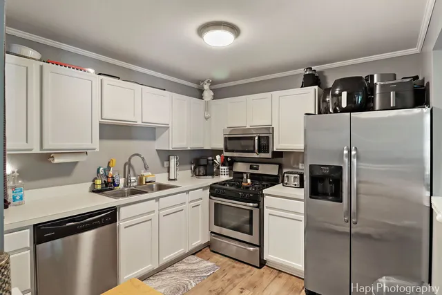 a kitchen with stainless steel appliances a refrigerator sink and cabinets