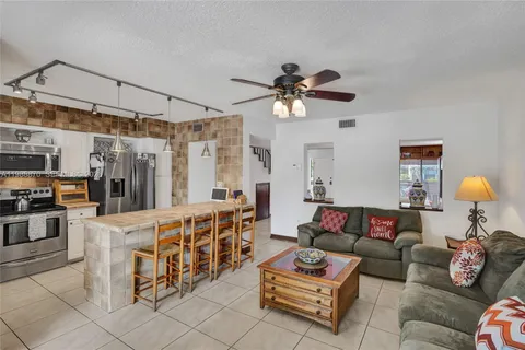 a living room with furniture a ceiling fan and a rug