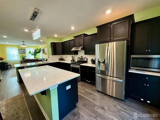 a kitchen with kitchen island a sink stainless steel appliances and refrigerator