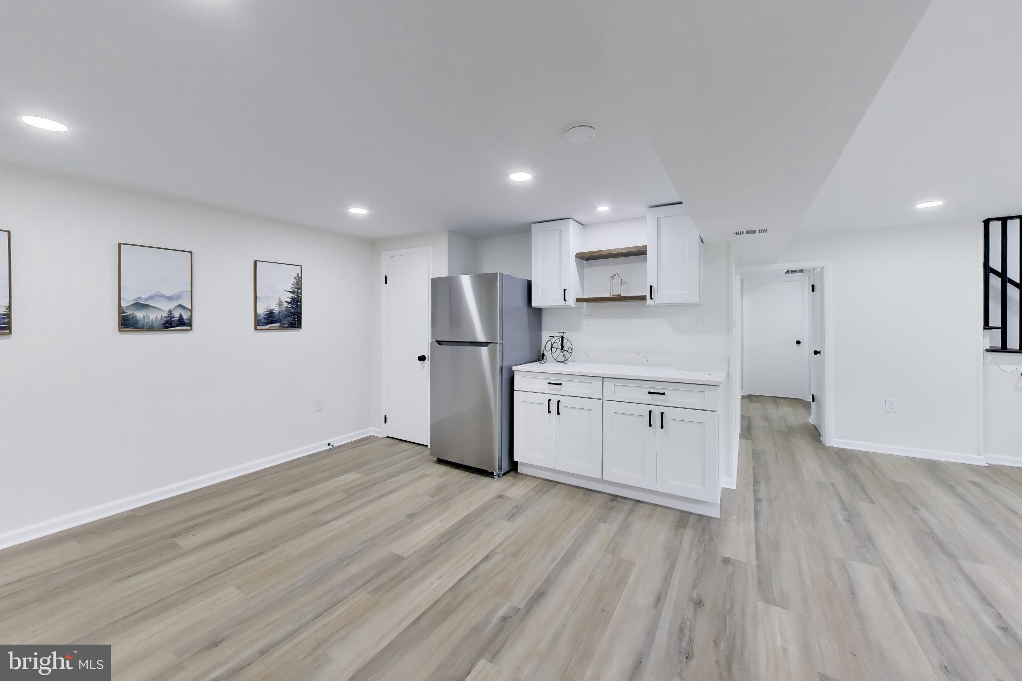 11309 Keystone Avenue Clinton, MD 20735 - Photo 22 of 36 a kitchen with white cabinets and wooden floor