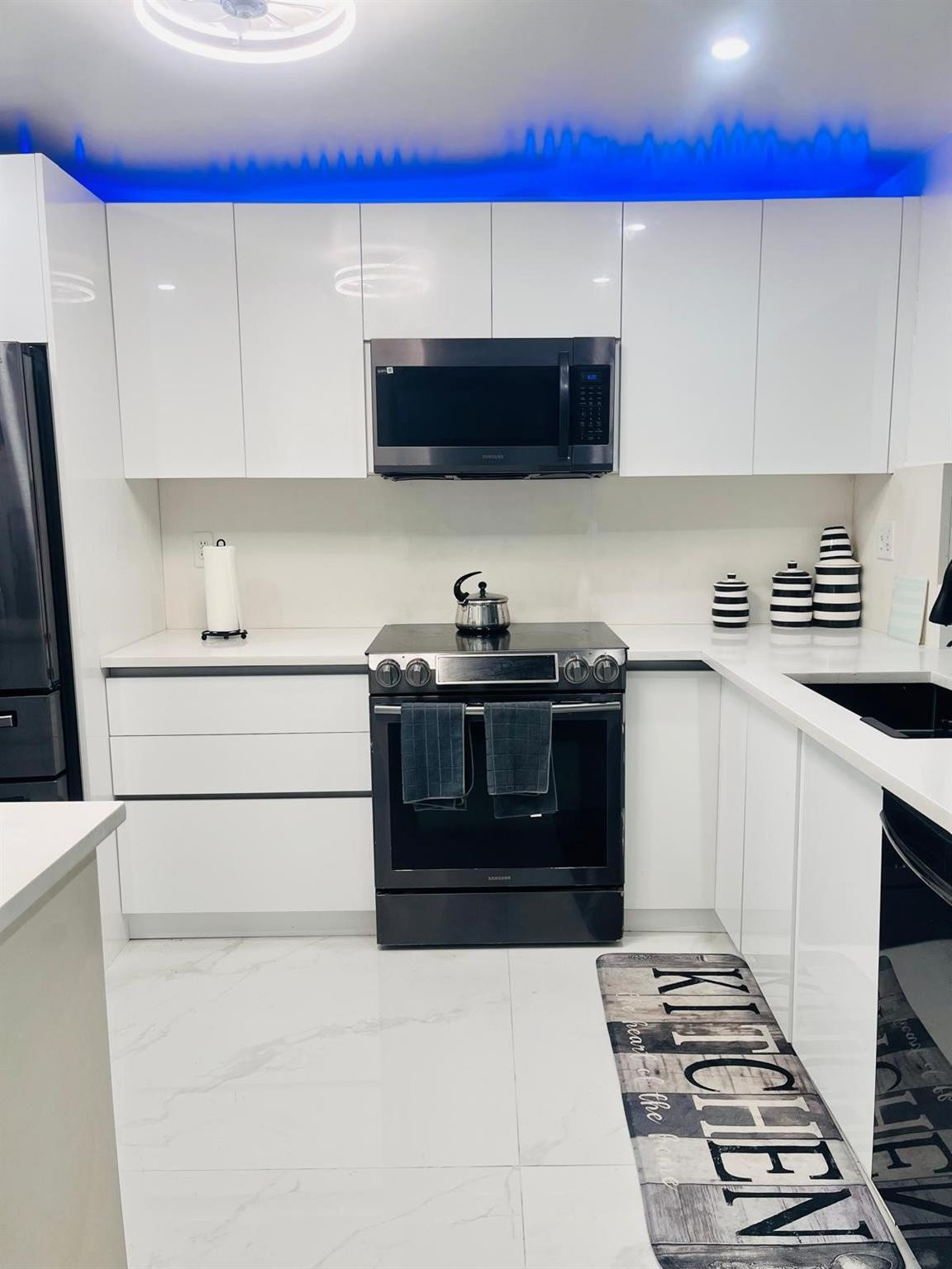 3910 Inverrary Boulevard, Unit 203B Lauderhill, FL 33319 - Photo 12 of 61 a kitchen with stainless steel appliances a stove a microwave and a sink