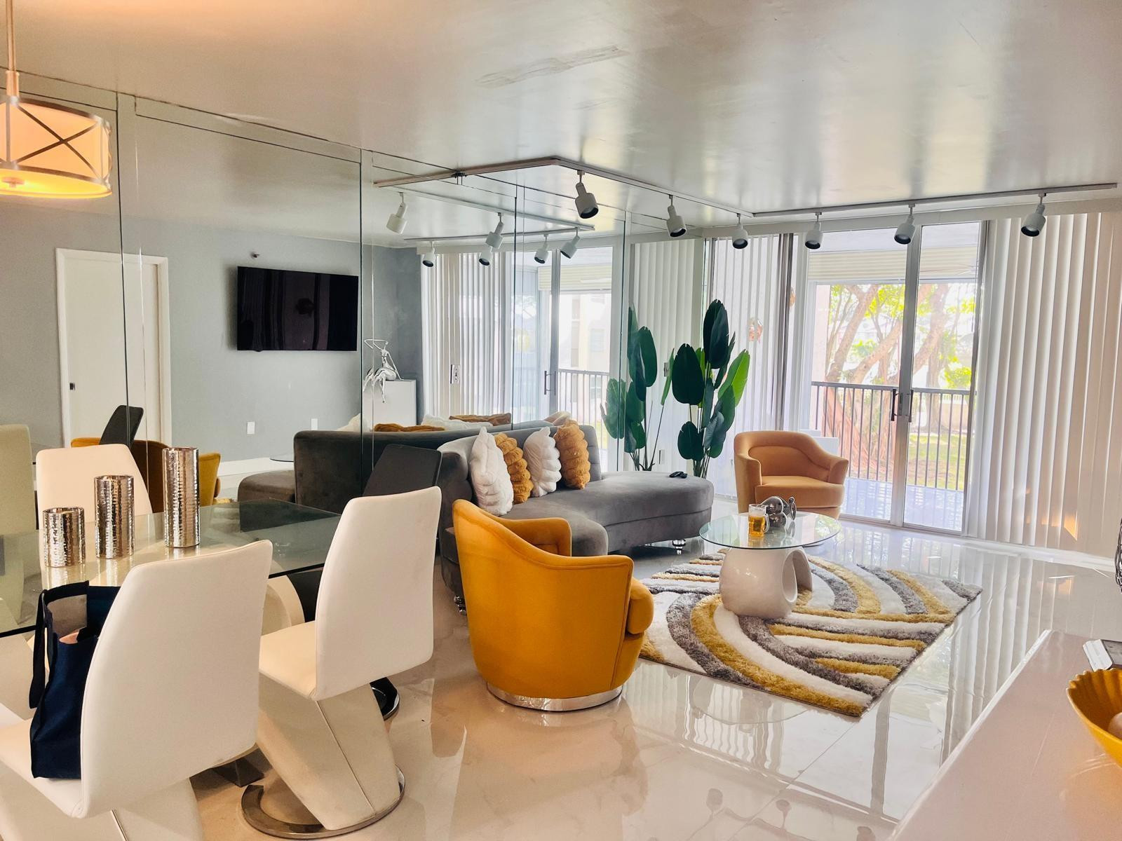 3910 Inverrary Boulevard, Unit 203B Lauderhill, FL 33319 - Photo 21 of 61 a living room with furniture a flat screen tv and a large window