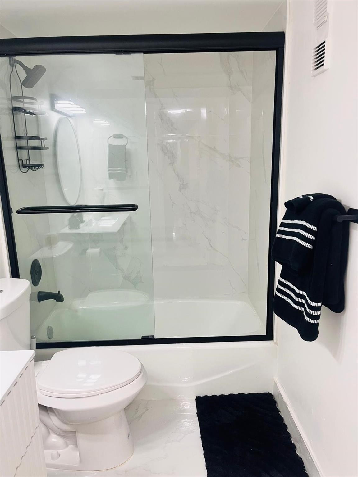 3910 Inverrary Boulevard, Unit 203B Lauderhill, FL 33319 - Photo 4 of 61 a bathroom with a shower a toilet and a mirror