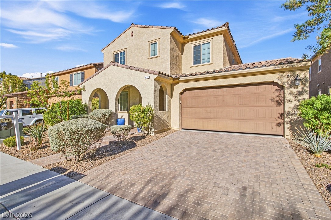 2182 Trivero Street Henderson, NV 89044 - Photo 5 of 50 A spacious paved driveway leads to a prominent double garage beneath classic tiled rooflines.