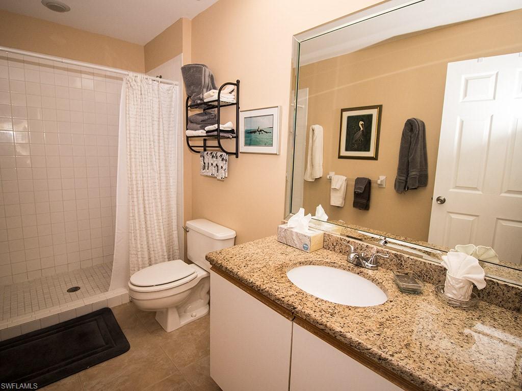 3321 Olympic Drive, Unit 623 Naples, FL 34105 - Photo 13 of 20 a bathroom with a granite countertop sink and a mirror