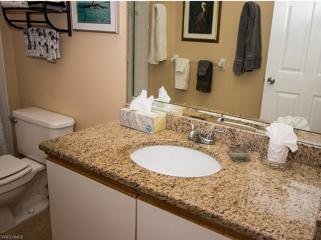 3321 Olympic Drive, Unit 623 Naples, FL 34105 - Photo 14 of 20 a bathroom with a granite countertop sink and a mirror