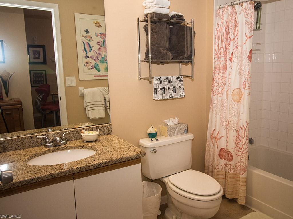 3321 Olympic Drive, Unit 623 Naples, FL 34105 - Photo 16 of 20 a bathroom with a granite countertop toilet sink and mirror
