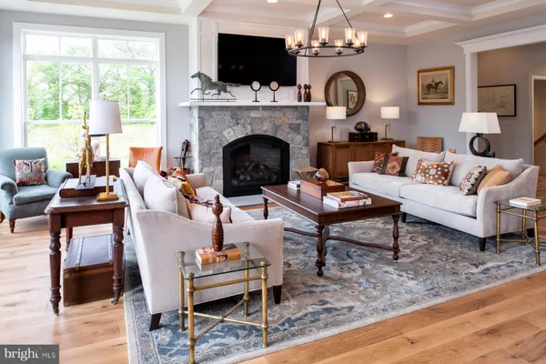 a living room with furniture a fireplace and a large window