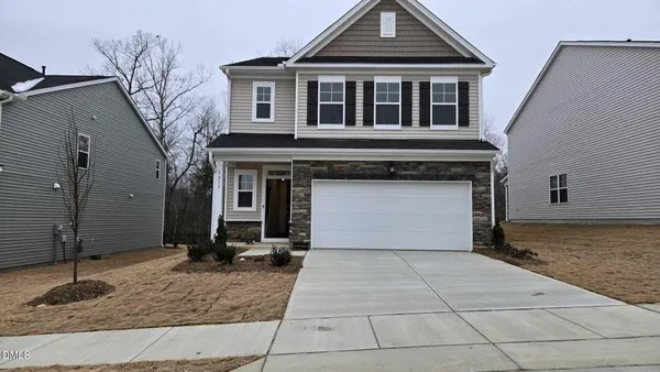 a front view of a house with a yard and garage