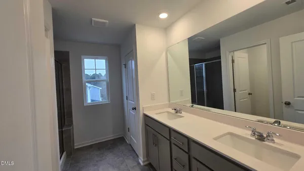 a bathroom with double sink and a mirror