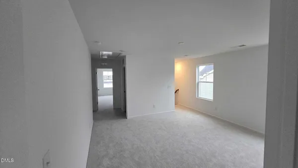 a view of an empty room with window and bathroom