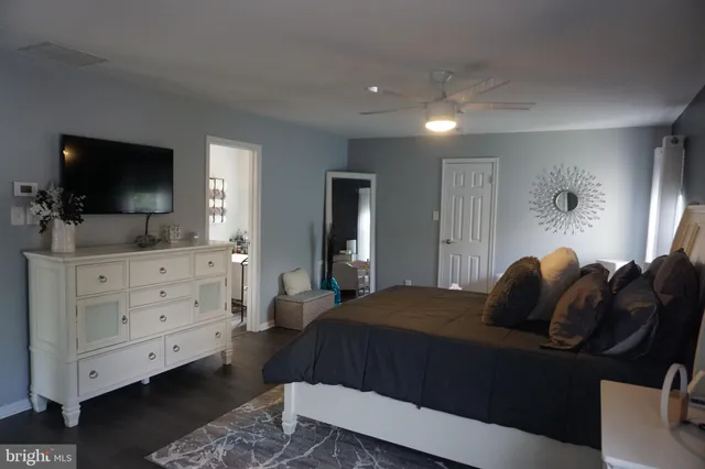 a bedroom with a bed and a flat tv screen on dresser