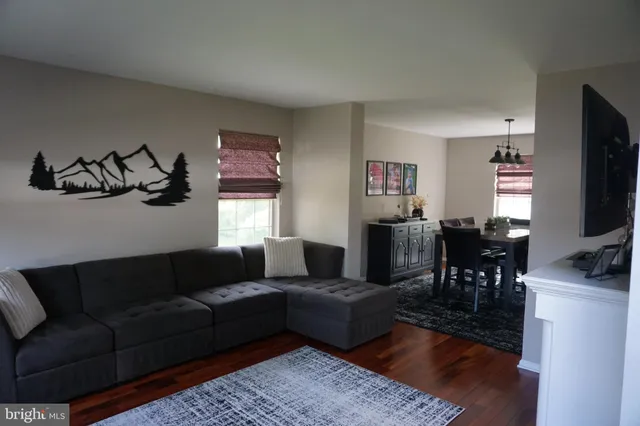 a living room with furniture a dining table and a flat screen tv