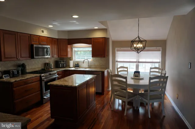 a kitchen with stainless steel appliances granite countertop wooden cabinets a stove top oven a sink and dishwasher