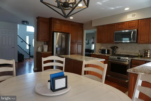 a kitchen with stainless steel appliances kitchen island granite countertop a stove and a microwave