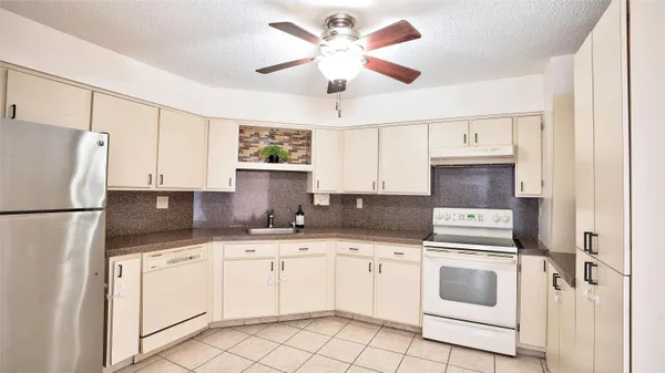 a kitchen with white cabinets sink and white appliances