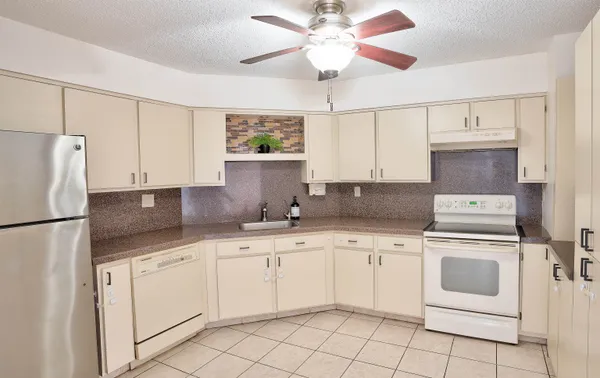 a kitchen with white cabinets sink and white appliances