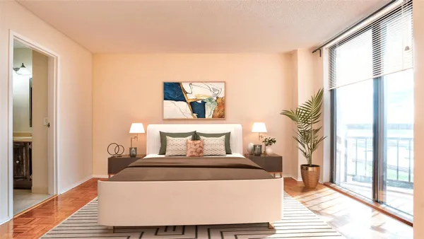a living room with furniture a large window and wooden floor