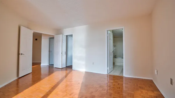 a view of empty room with wooden floor