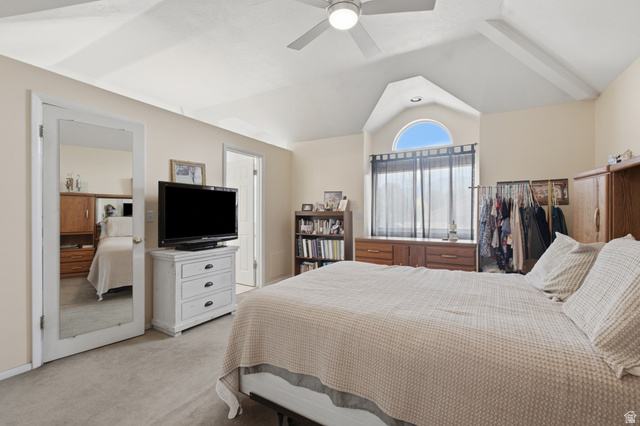 5788 Walden Ridge Drive Murray, UT 84123 - Photo 15 of 29 Vaulted ceiling bedroom featuring a ceiling fan, arched window, carpeted flooring, and a mirrored door