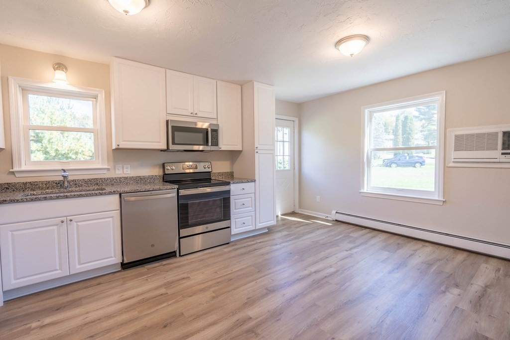 6 Meadowbrook Lane Spencer, MA 01562 - Photo 9 of 39 a kitchen with granite countertop a stove a sink and a microwave