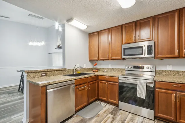 a kitchen with stainless steel appliances granite countertop a sink stove and microwave