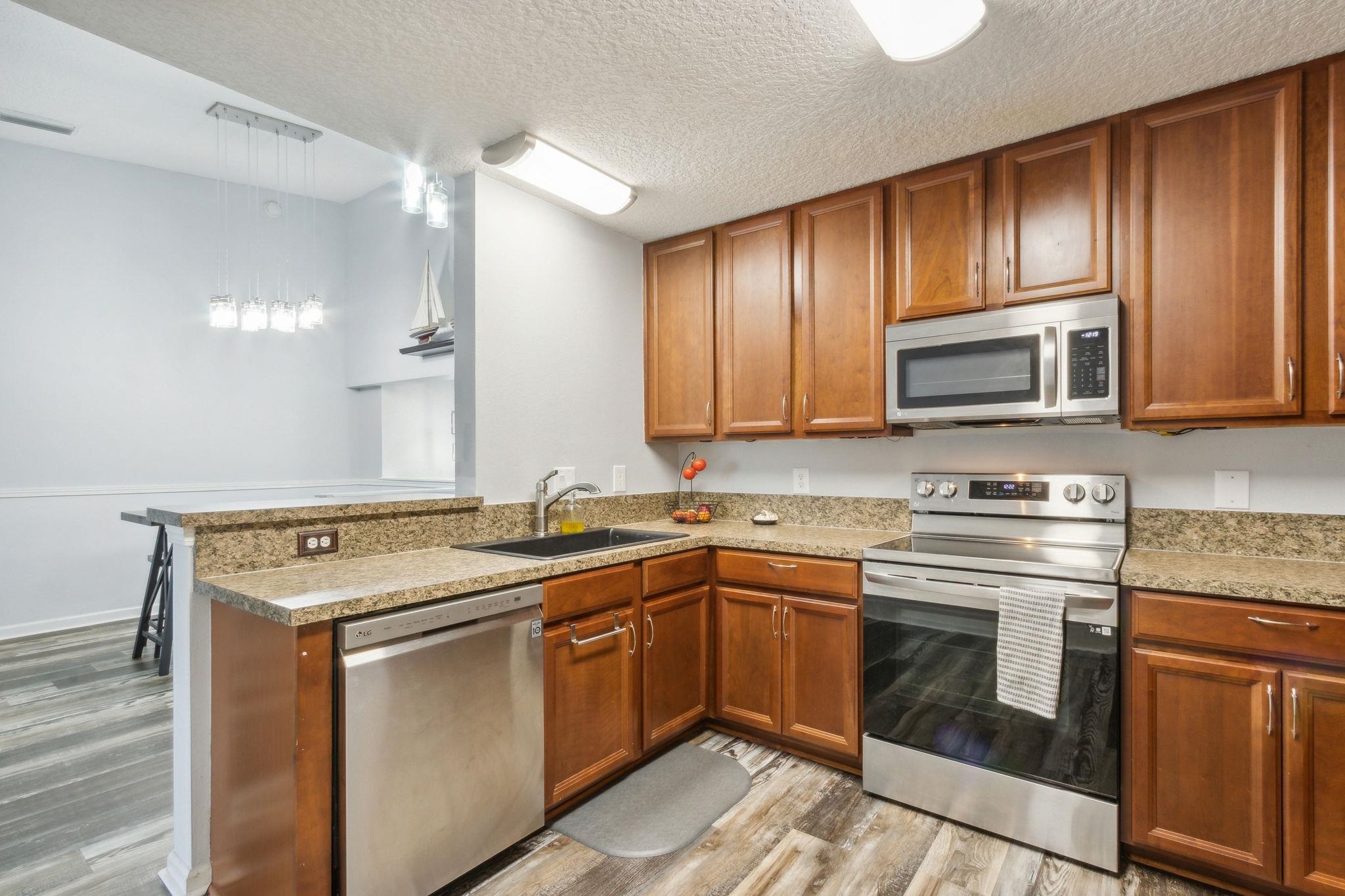 404 Golden Lake Loop St. Augustine, FL 32084 - Photo 11 of 38 a kitchen with stainless steel appliances granite countertop a sink stove and microwave